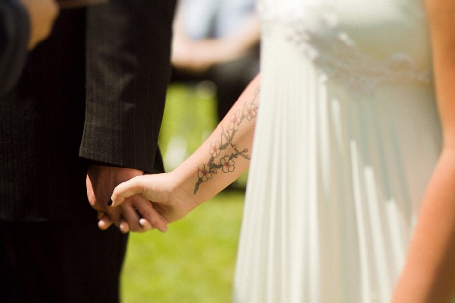 bride and groom holds hands during their wedding ceremony in Fergus, Ontario by their wedding photographer