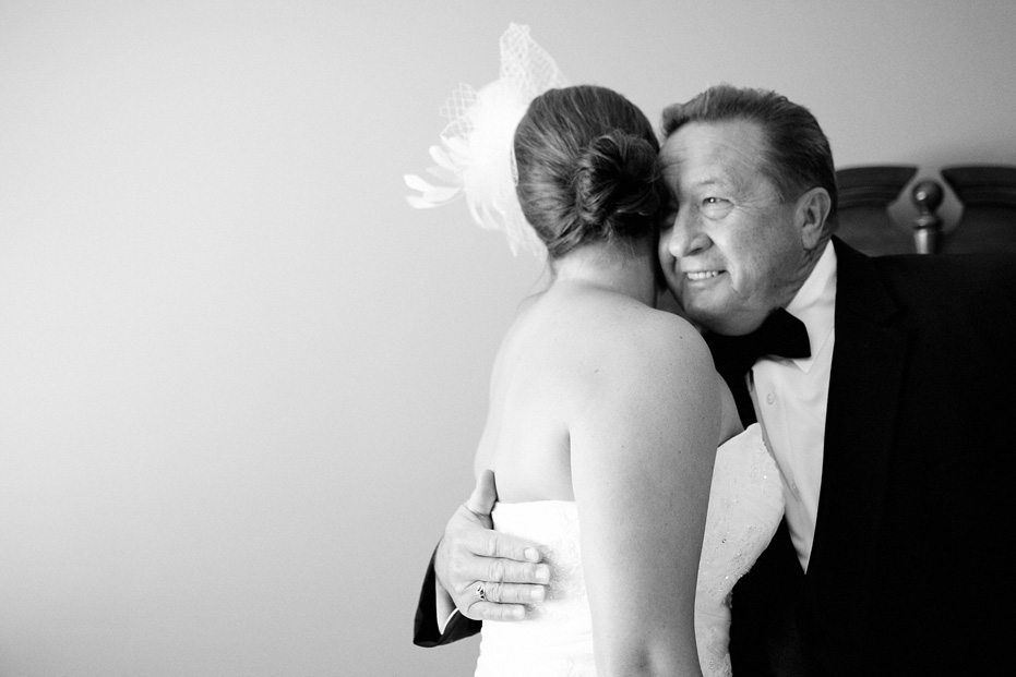 the proud father of the bride hugs his daughter the morning of her wedding day