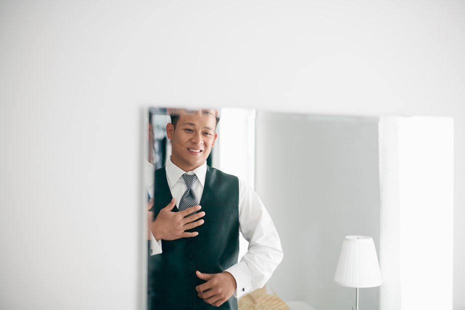 a groom happily gets ready for his wedding in Kitchener, Ontario