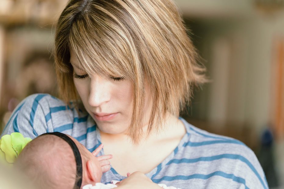 A mother cradles her newborn daughter